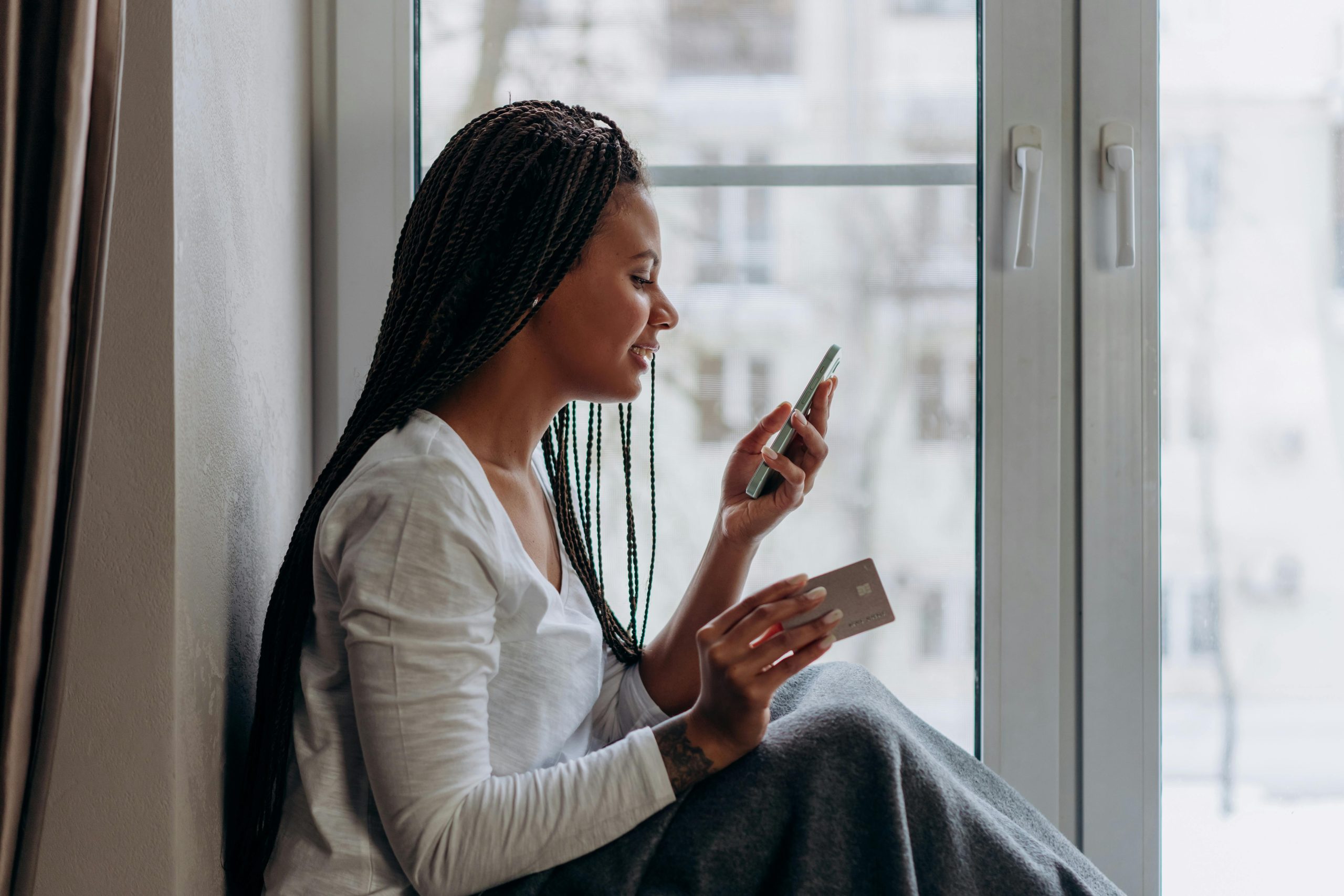 Money management tips. Woman holding a phone and credit card